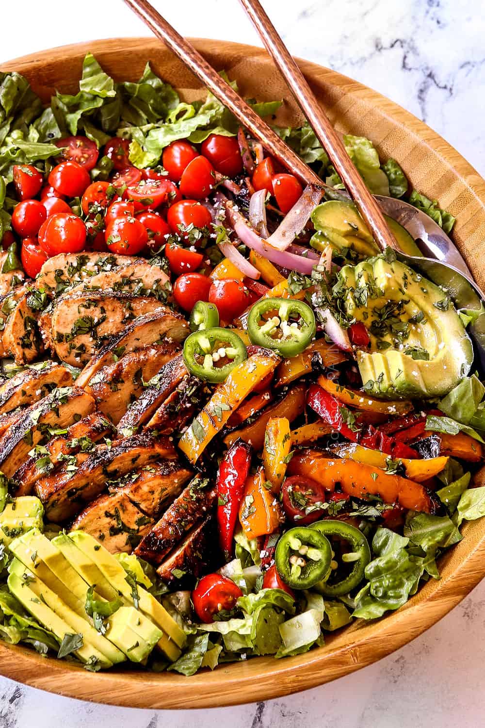 chicken fajita salad (chicken salad recipe) with chicken, bell peppers, red onions, tomatoes, avocados, cilantro in a wood bowl