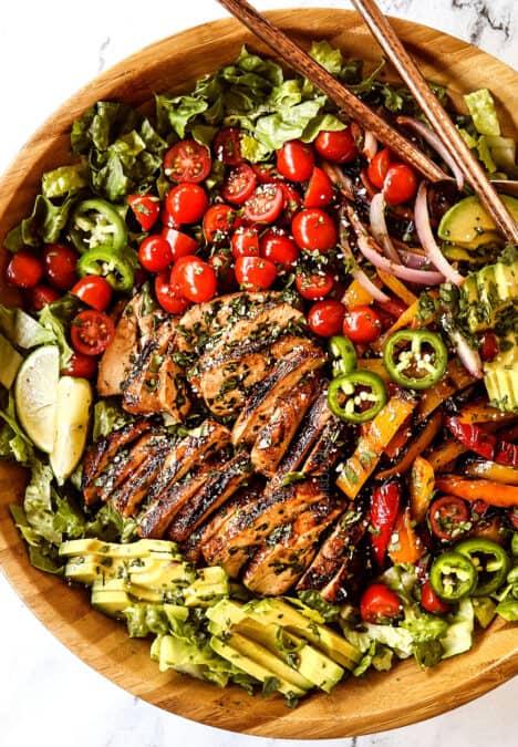 top view of chicken fajita salad (chicken salad recipe) in a wood bowl with chicken, tomatoes, avocados, bell peppers