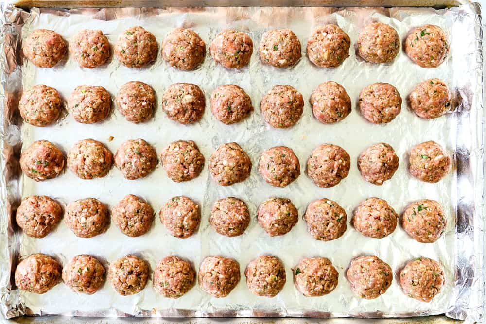 showing how to make Greek Meatball recipe (Keftedes) with lamb by rolling meatball and placing them on a baking sheet