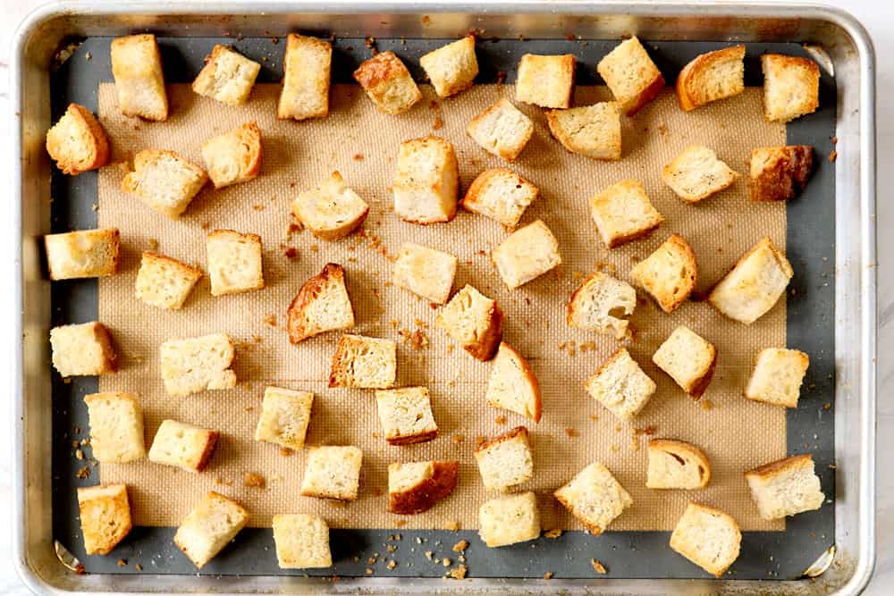 showing how to make Panzanella by toasting bread cubes on a baking sheet