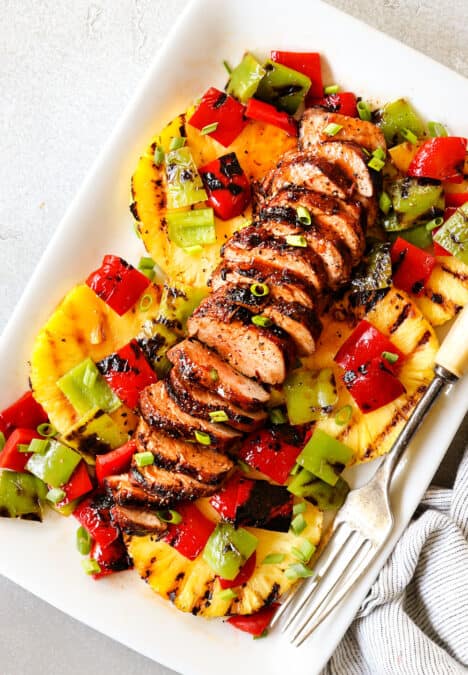 top view of marinated pork tenderloin sliced on a white platter with