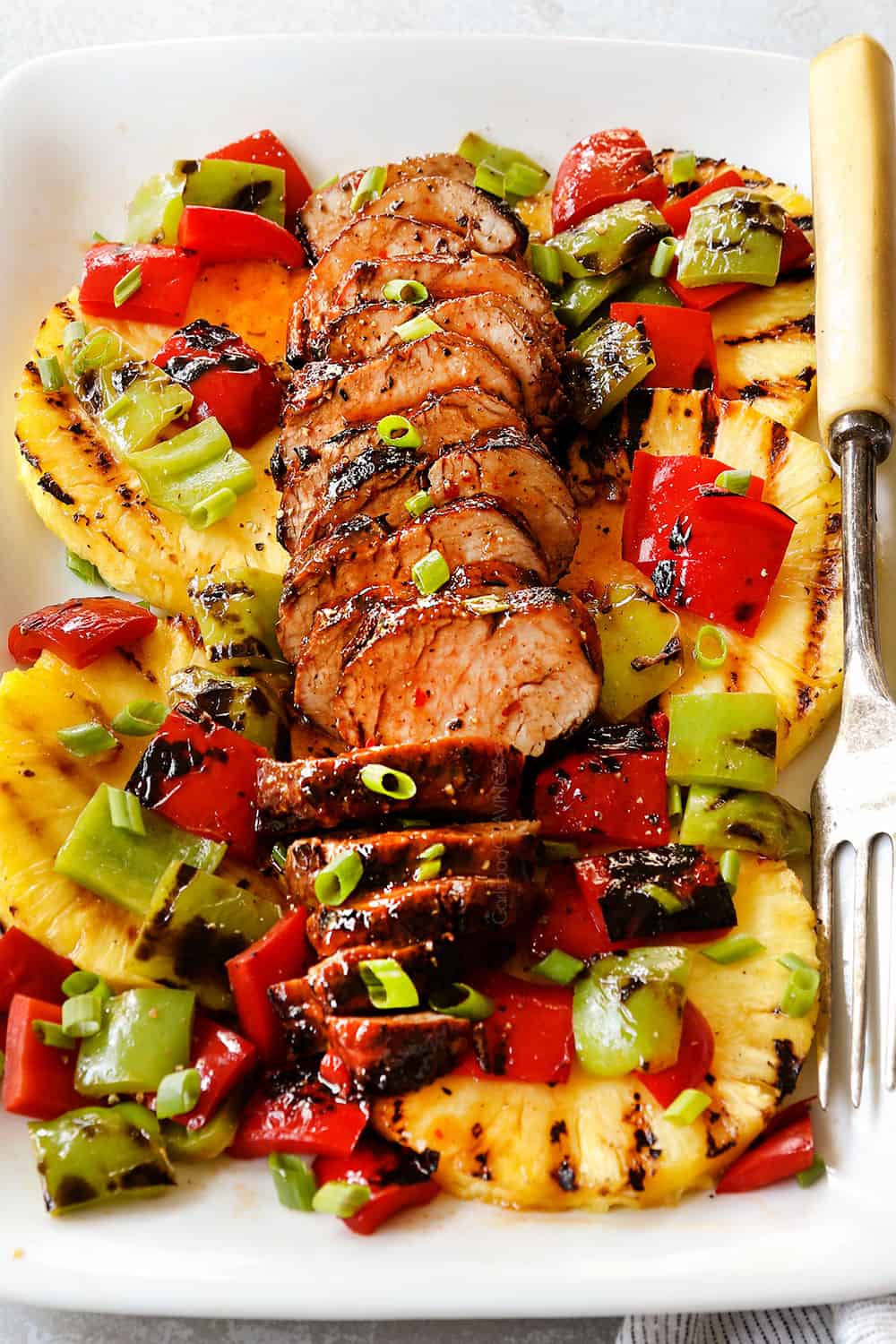 up close of sliced marinated pork on a white platter