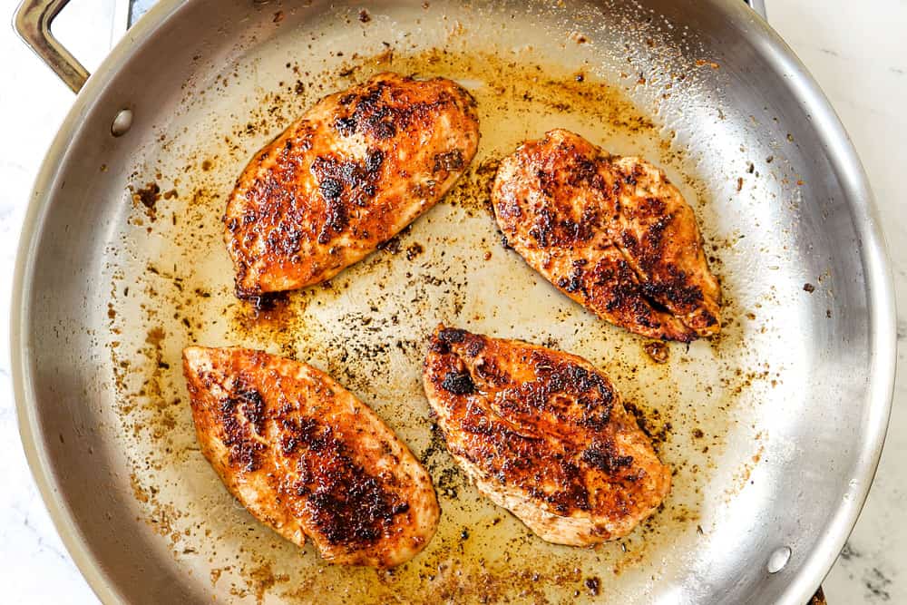 showing how to make blackened chicken recipe by cooking chicken in a skillet until a dark crust forms