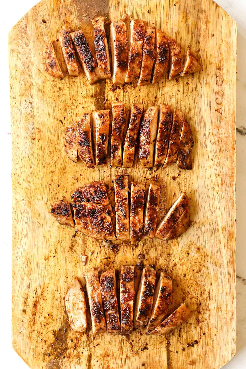 showing how to make blackened chicken recipe by slicing cooked chicken into strips