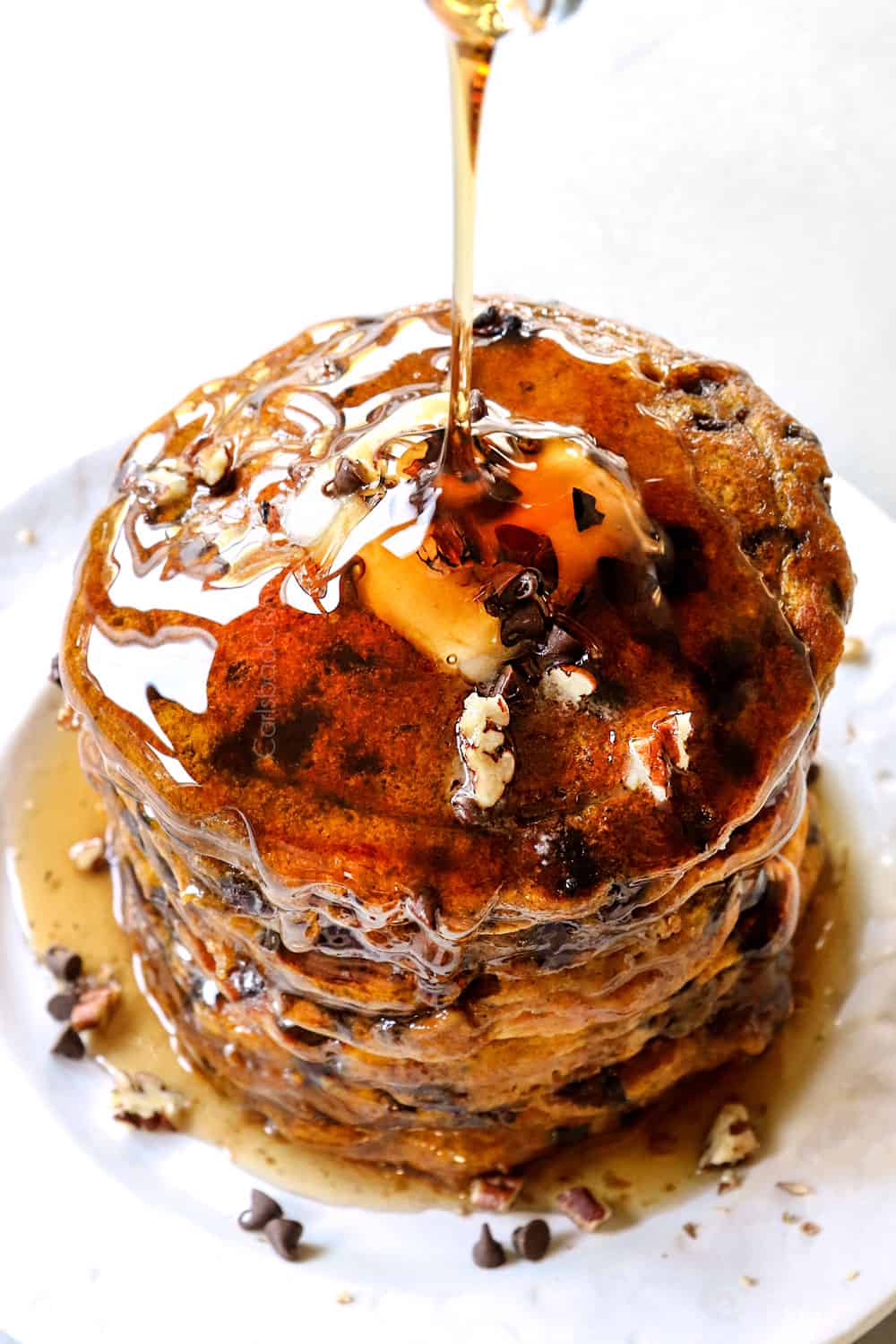 pouring syrup of a stack of pumpkin spice pancakes
