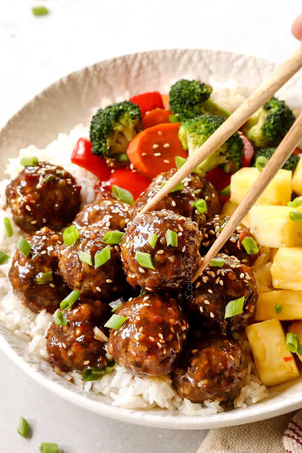 picking up teriyaki meatballs with chopstick