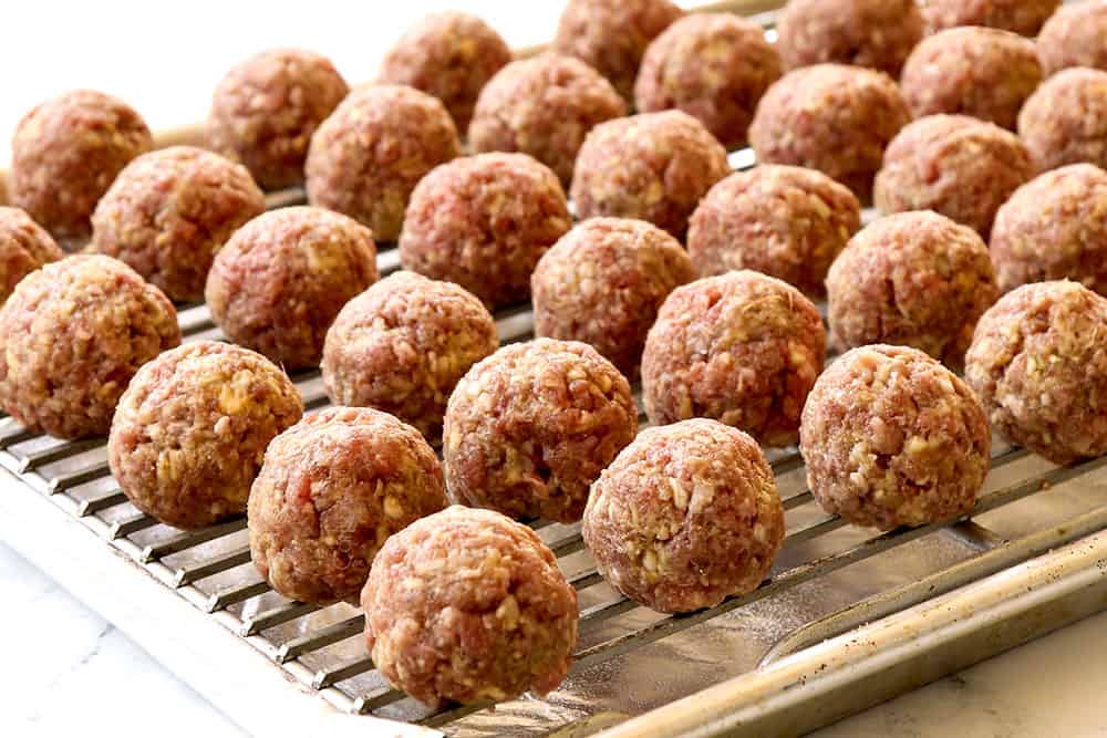 showing how to make teriyaki meatball recipe by placing rolled meatballs on a baking sheet with baking rack on top