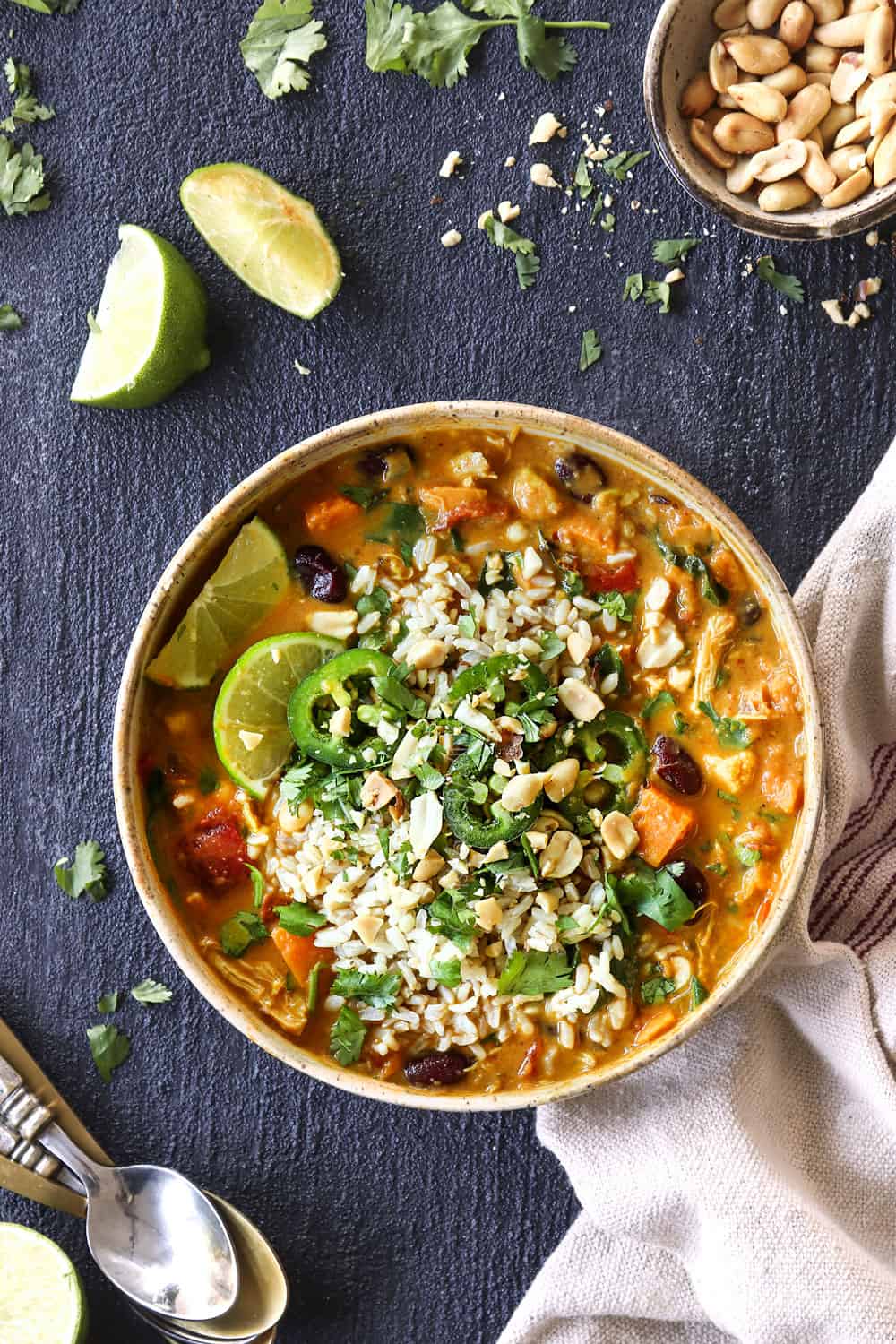 showing how to serve African Peanut Soup (African Peanut Stew) by topping with cilantro and serving it in a bowl with rice