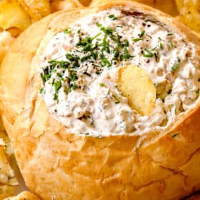 up close of dipping a chip into French Onion Dip