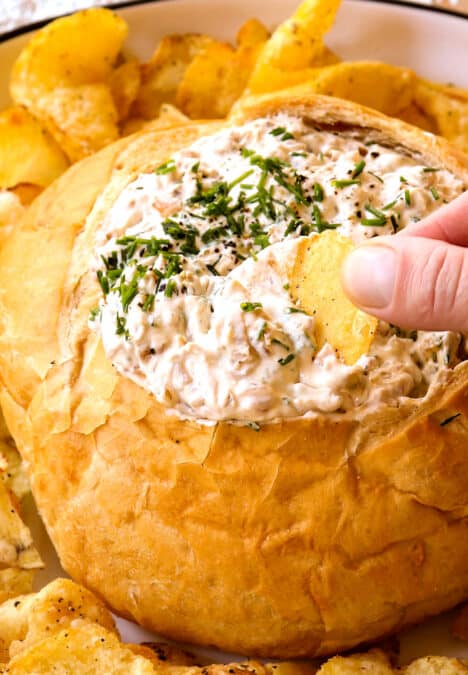 up close of dipping a chip into French Onion Dip