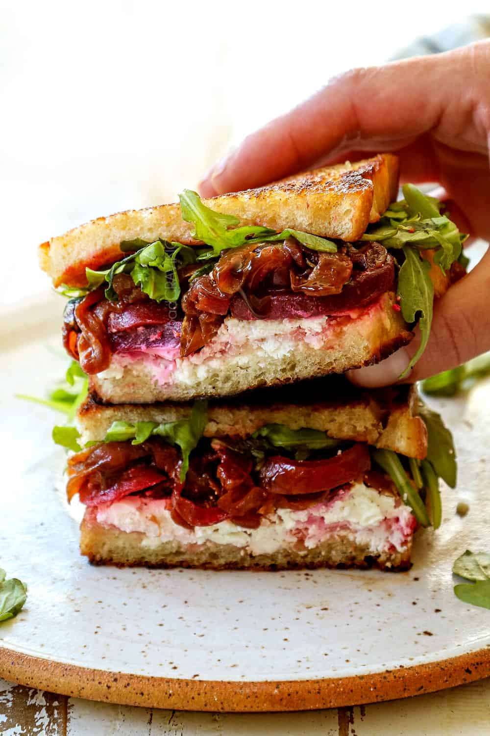 grilled cheese sandwich recipe stacked on top of each other with goat cheese, caramelized onions and arugula