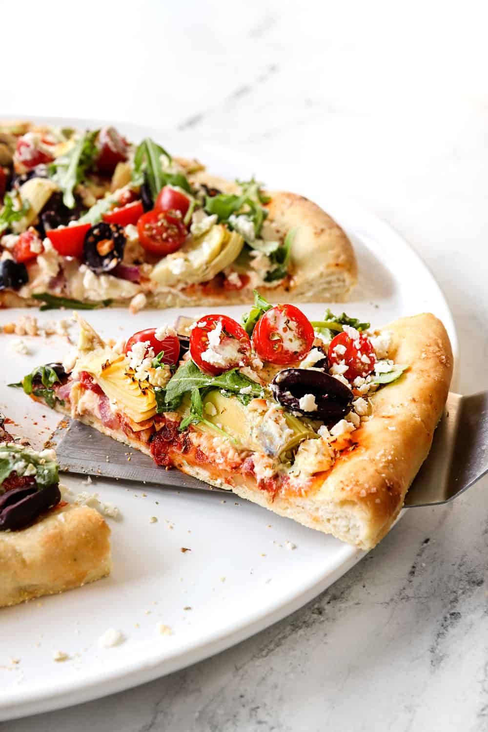 picking up a slice of Greek pizza with a spatula