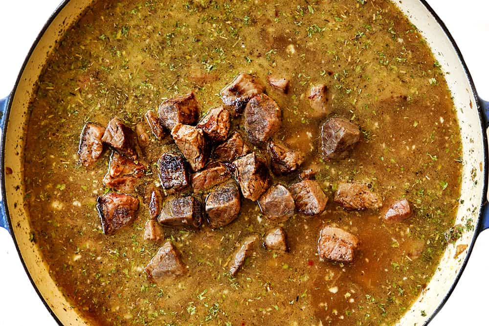 showing how to make beef and noodles recipe by adding beef tips to the broth to simmer