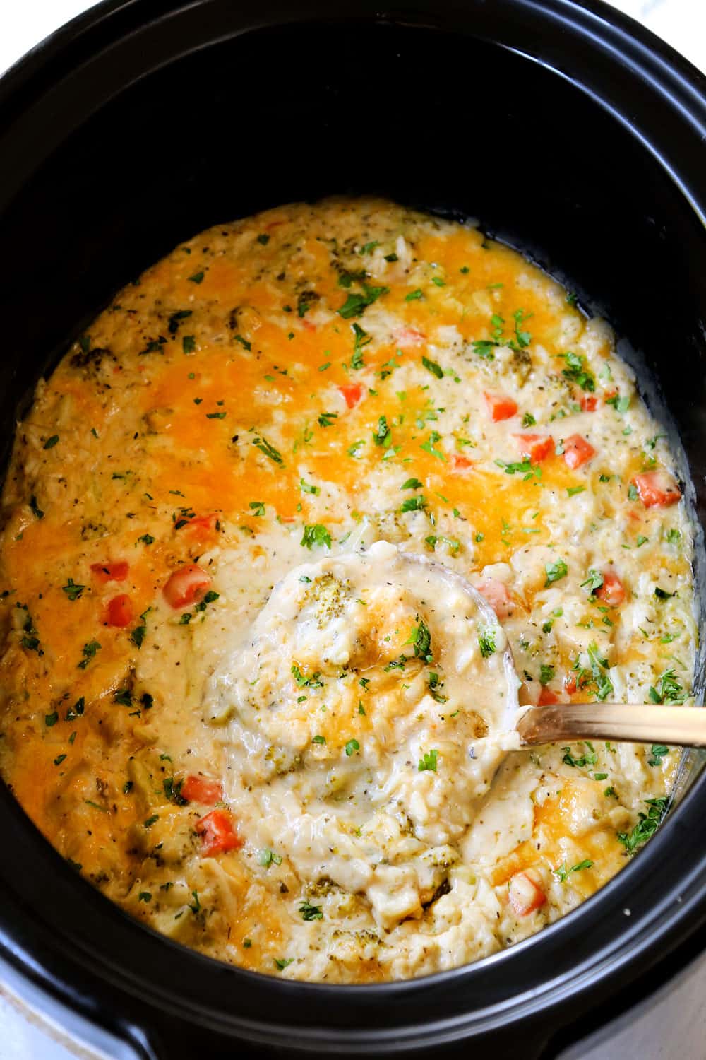 up close of a creamy crockpot chicken and rice with cheese and veggies