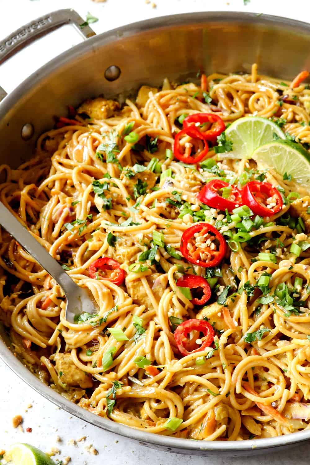 Peanut Sauce Noodles in a skillet twirled on a fork showing how creamy they are