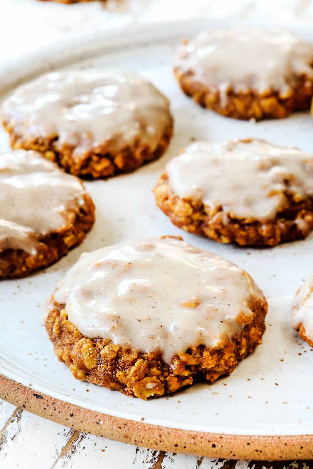 up close of a soft and chewy pumpkin cookie on a plate with icing