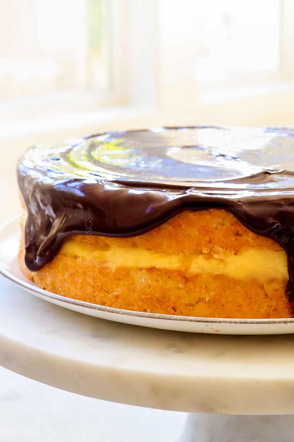 Boston Cream Pie recipe on a white cake pedestal