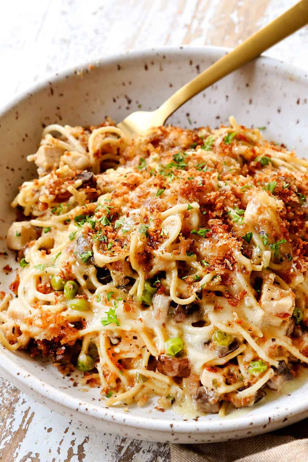 up close of Turkey Tetrazzini recipe in a bowl with a fork showing how to serve