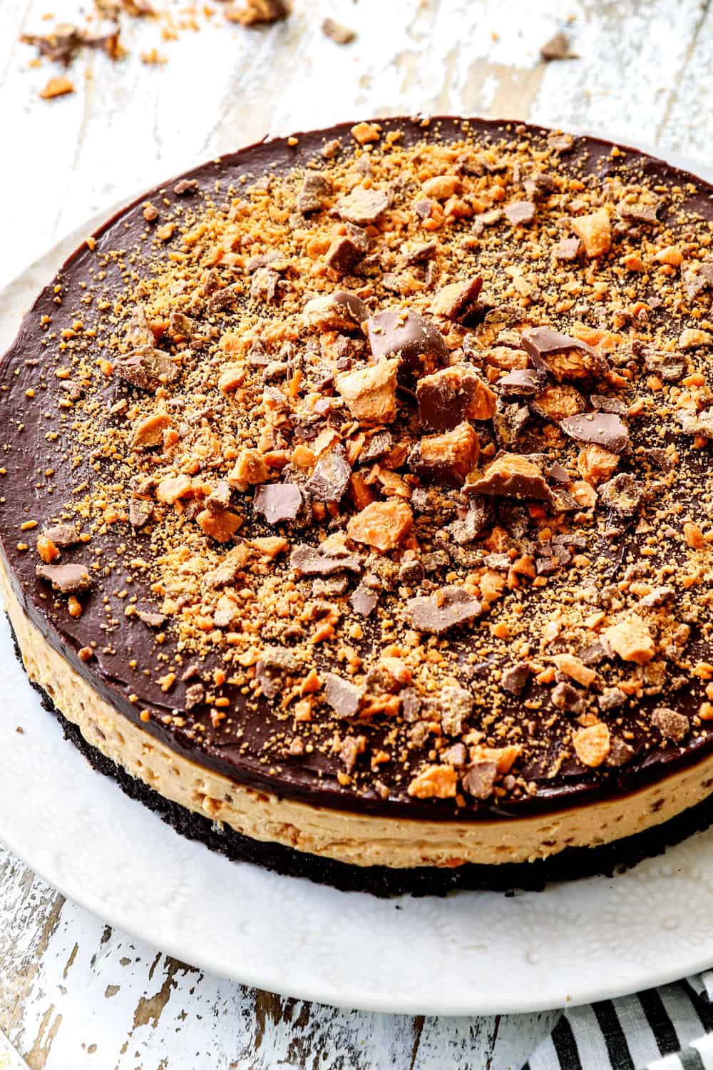 side view of Butterfinger Pie with peanut butter filling, chocolate ganache and chopped Butterfingers