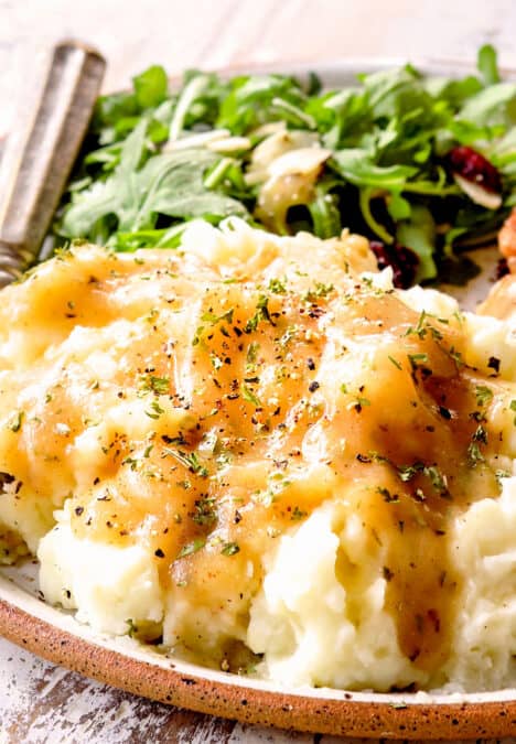 up close of chicken broth gravy over potatoes with herbs