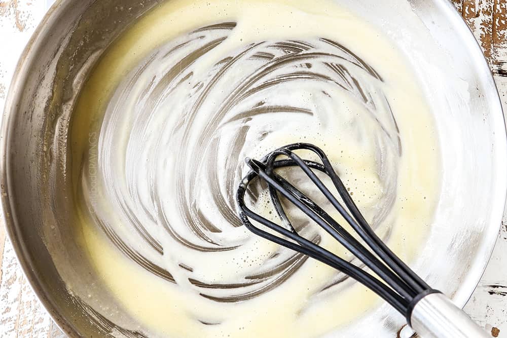 showing how to make chicken gravy recipe by whisking flour with butter in skillet