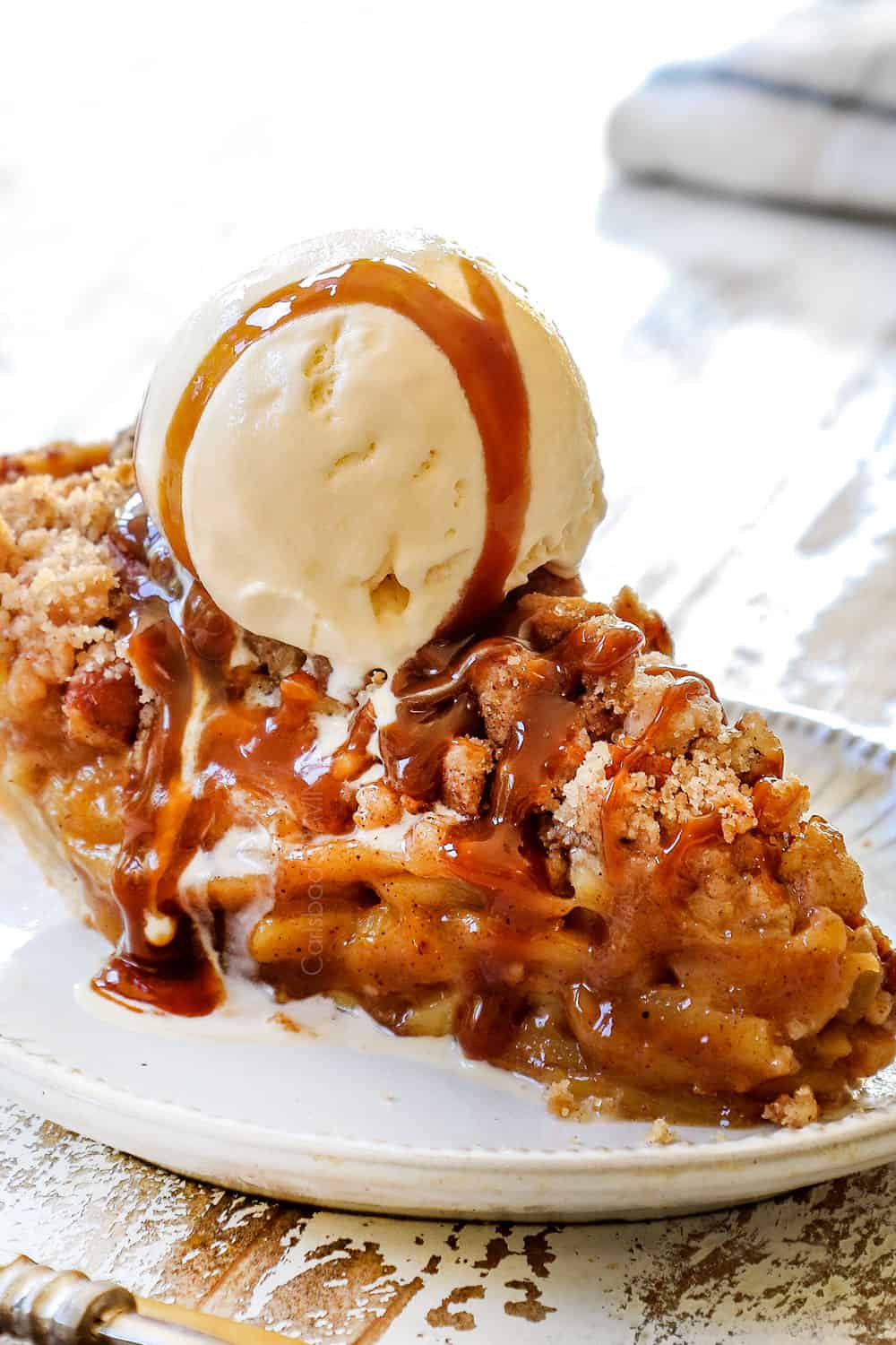 a slice Dutch Apple Pie (Apple Crumble Pie) with ice cream and caramel sauce