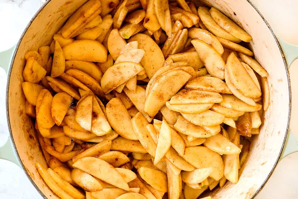 showing how to make Dutch Apple Pie (Apple Crumble Pie) by adding sliced apples, brown sugar, sugar, cinnamon, nutmeg and cloves to a pot