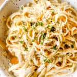 top view of fettuccine Alfredo in a bowl with freshly cracked pepper showing how creamy it is