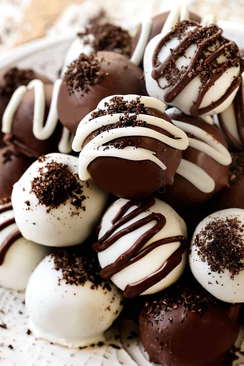 up close of Oreo cookie balls with drizzled chocolate and crushed Oreos
