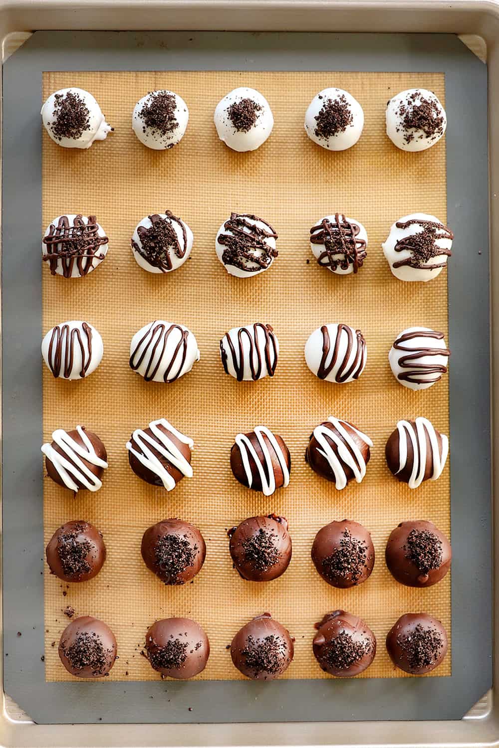 showing how to make Oreo Ball Truffles by drizzling the Oreo Balls with chocolate and then topping with crushed Oreos