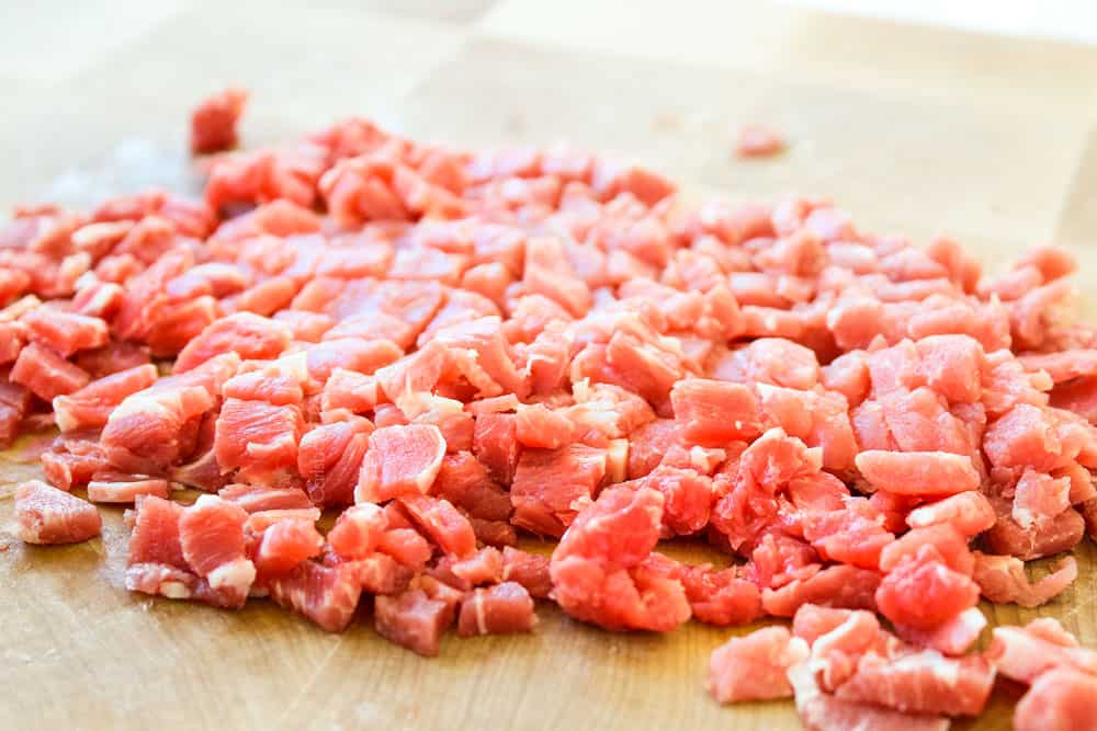 showing how to make Philly cheesesteak dip by finely chopping the steak