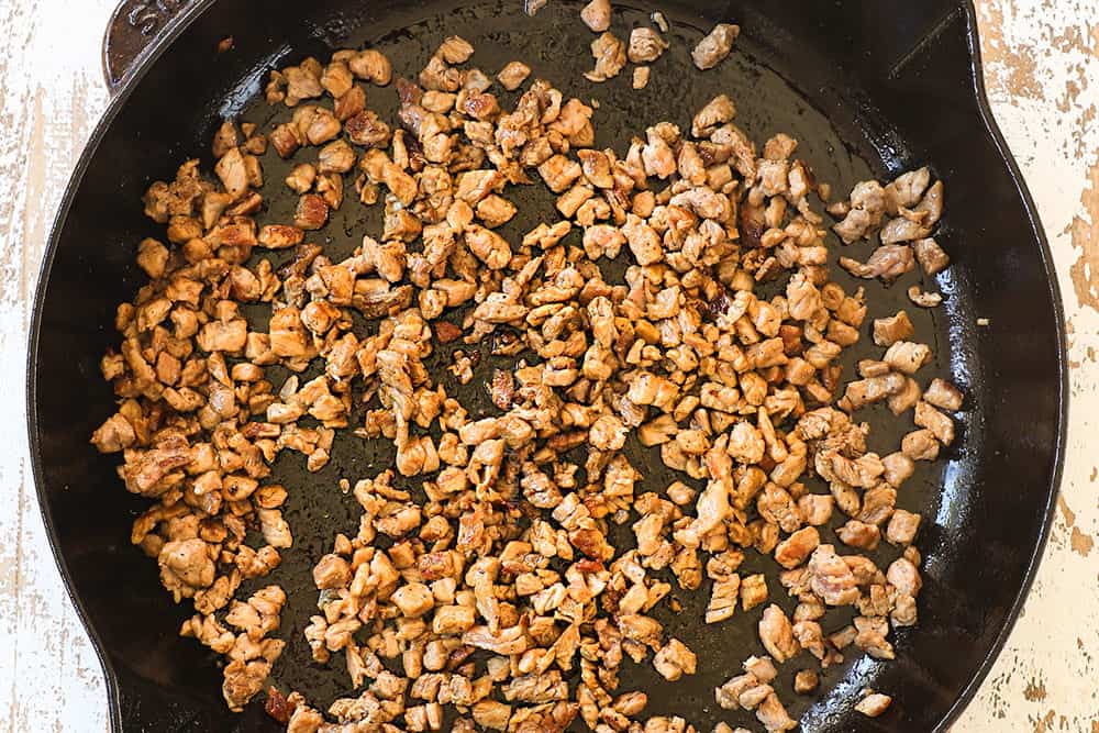 showing how to make Philly cheesesteak dip by cooking the steak in a skillet