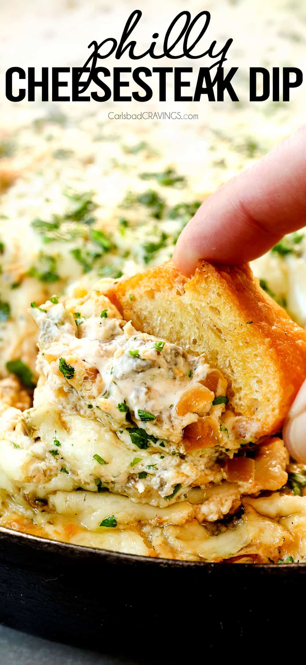 up close of scooping up Philly cheesesteak dip showing how creamy it is showing