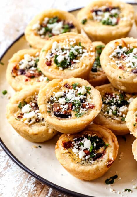 a stack of mini quiche on a plate showing how flaky the crust is