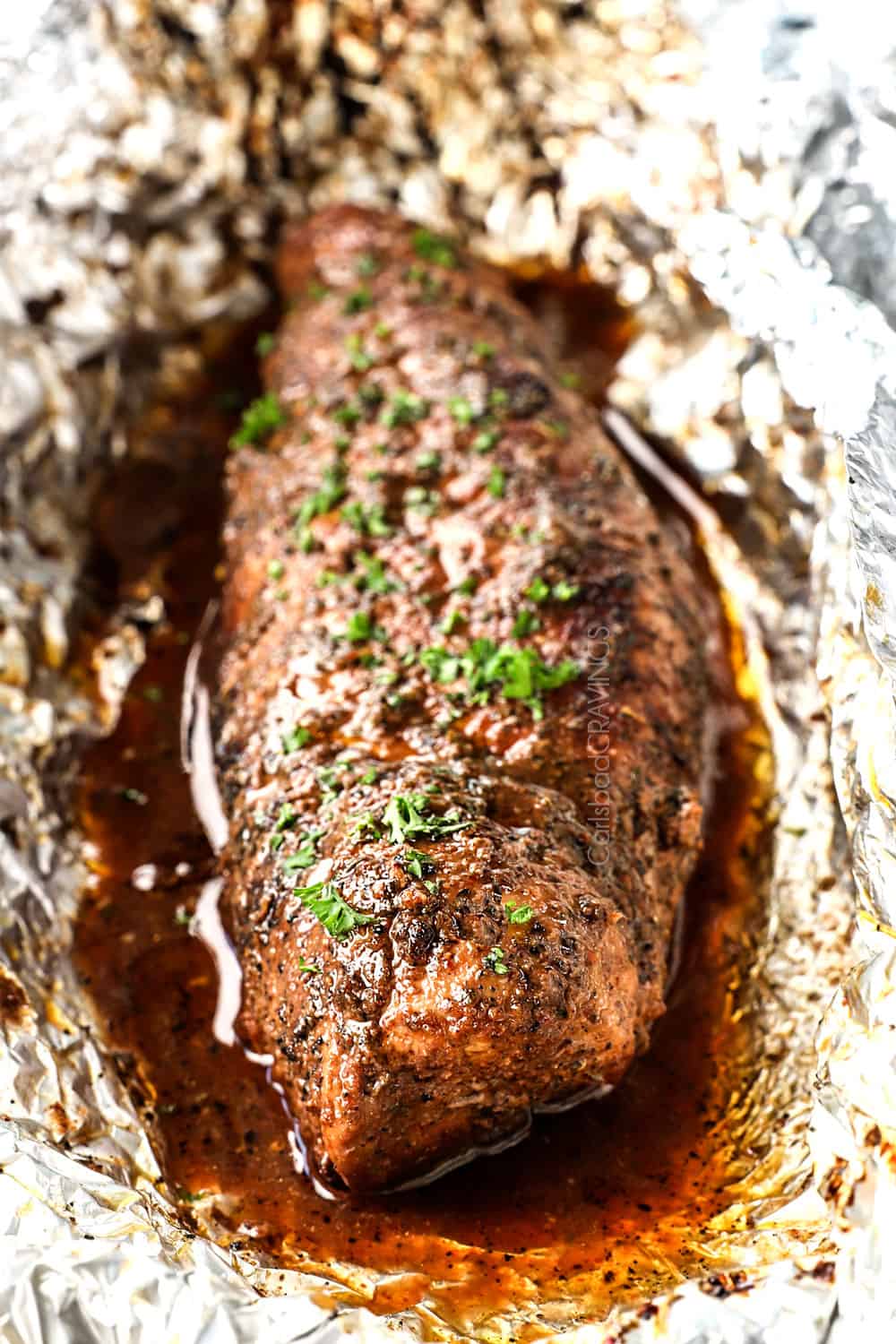 showing how to cook pork tenderloin by garnishing with parsley