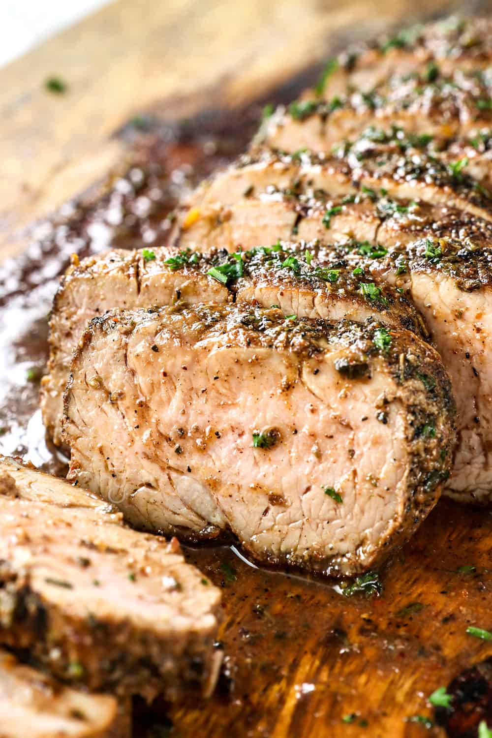 up close of a slice of balsamic pork tenderloin roasted in the oven showing how juicy it is