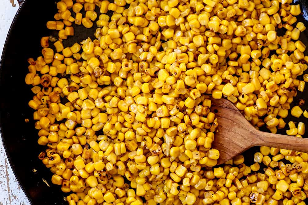 showing how to make corn dip recipe by charring corn in a cast iron skillet
