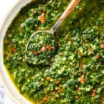 top view of the best chimichurri sauce recipe with parsley, oregano, red chili flakes, garlic and olive oil