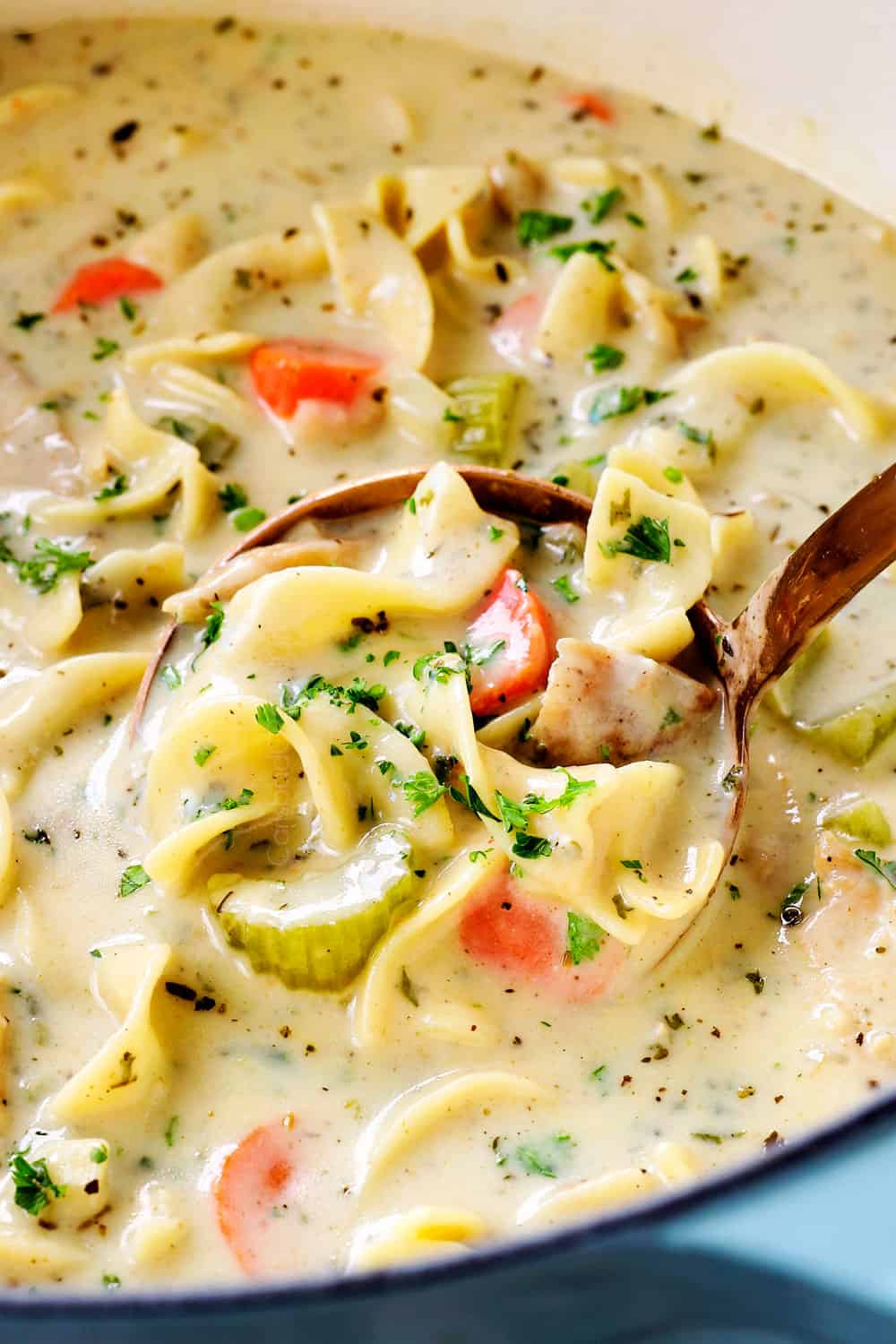 a ladle full of creamy chicken noodle soup recipe showing how creamy it is