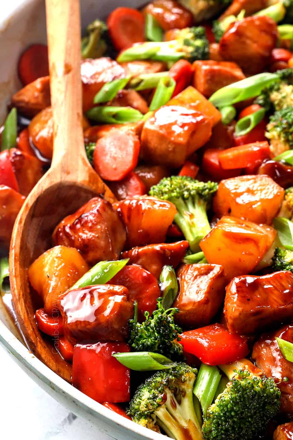 up close of scooping up teriyaki chicken stir fry showing how thick and sticky the teriyaki sauce is