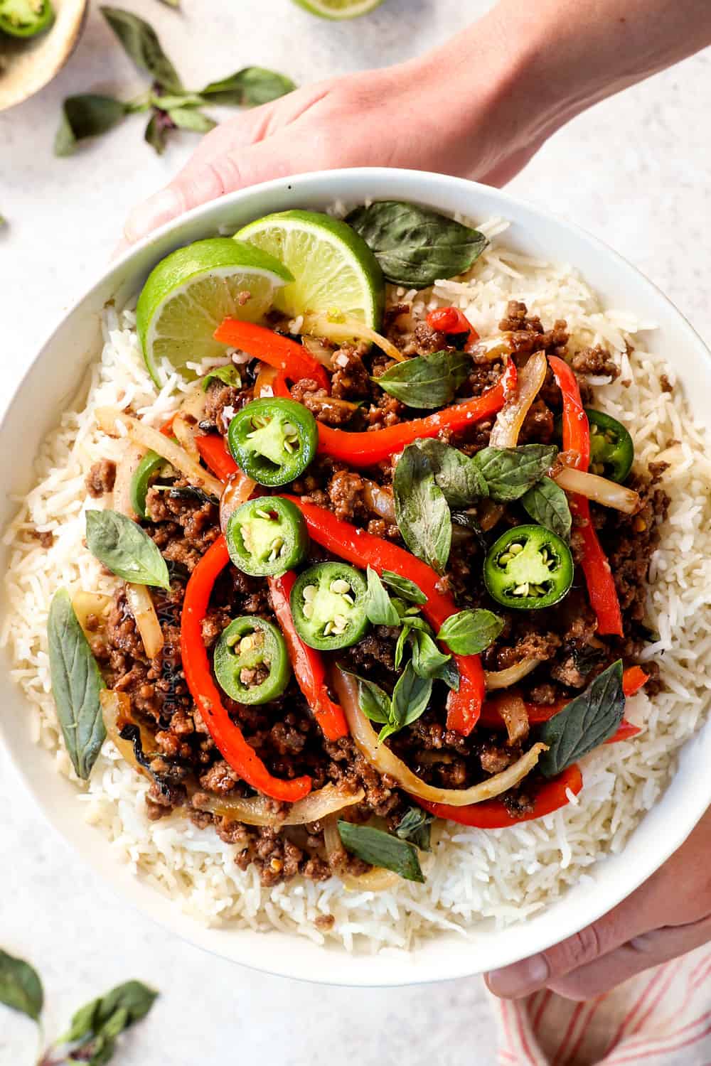 top view of holding a bowl of Pad Gra Prow (Thai Basil Beef)