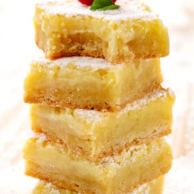 a stack of Gooey Butter Cake recipe with a bite out of one of the squares showing how creamy they are