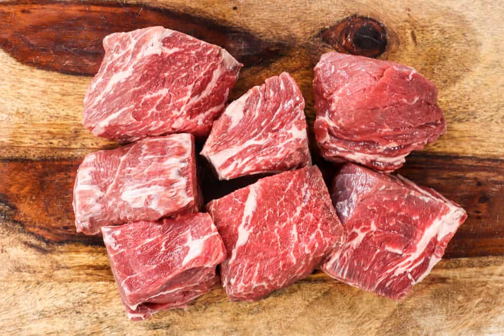 showing how to make shredded beef taco recipe by cutting chuck roast into 7 pieces