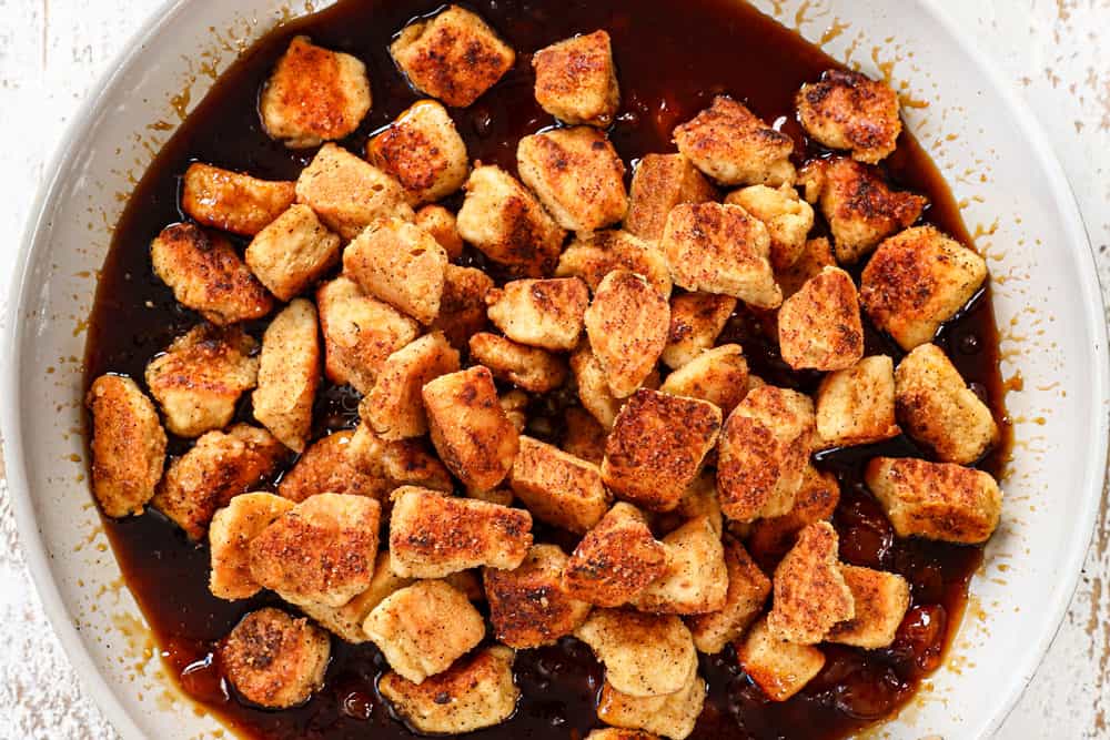 showing how to make apricot chicken recipe by tossing the crispy cooked chicken with the apricot sauce