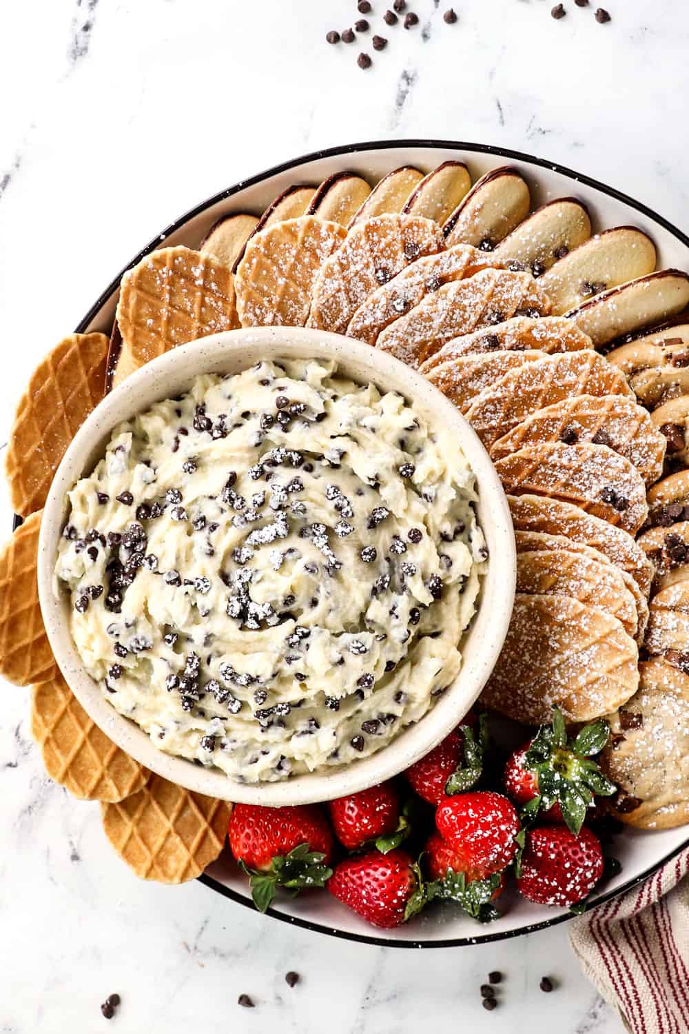 top view showing how to serve cannoli dip on a platter with waffle cookies, strawberries, Milano cookies, chocolate chip cookies