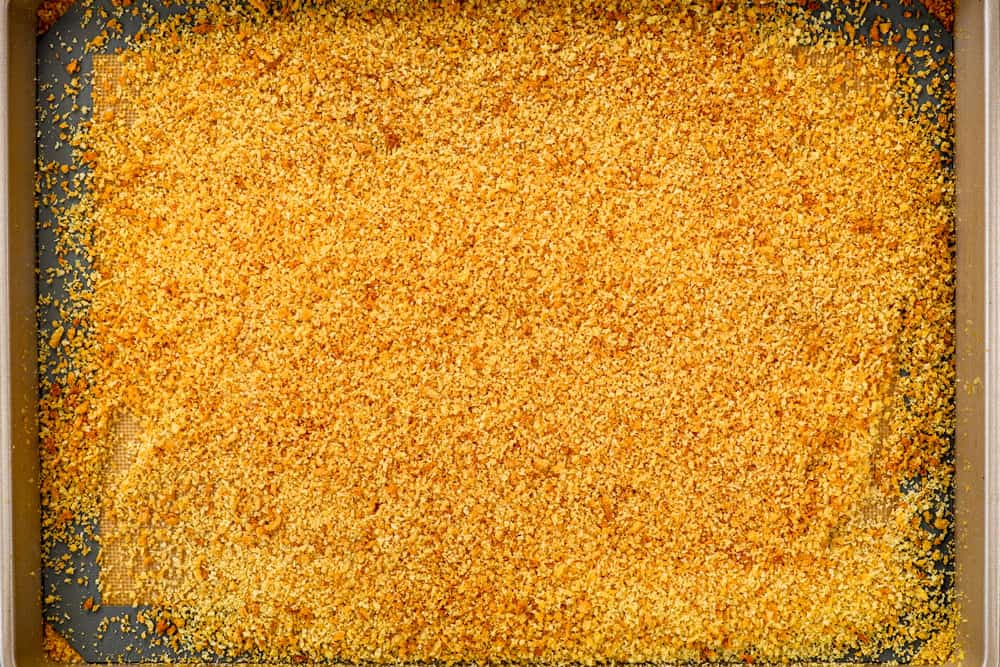 showing how to make fish sticks by toasting panko on a baking sheet in the oven until golden