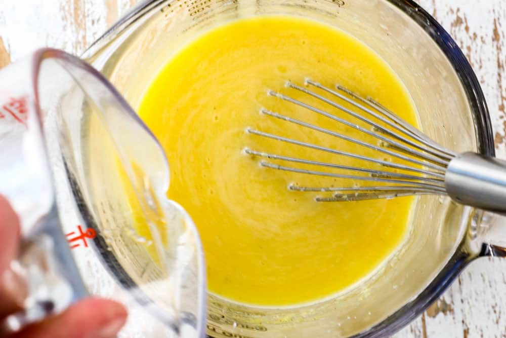 showing how to make spaghetti carbonara recipe by adding starchy pasta water to the eggs and cheese