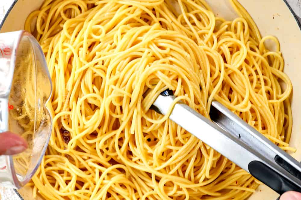 showing how to make carbonara recipe by tossing spaghetti with the pork grease and ½ cup starchy pasta water