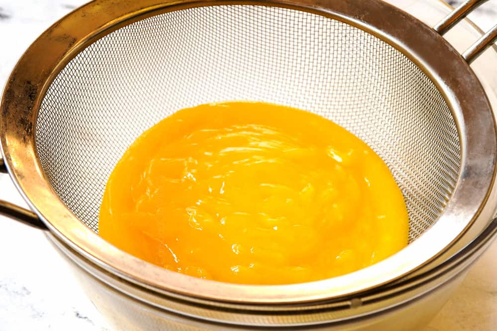 showing how to make lemon curd recipe by straining lemon curd through a fine mesh sieve to make it extra creamy and smooth