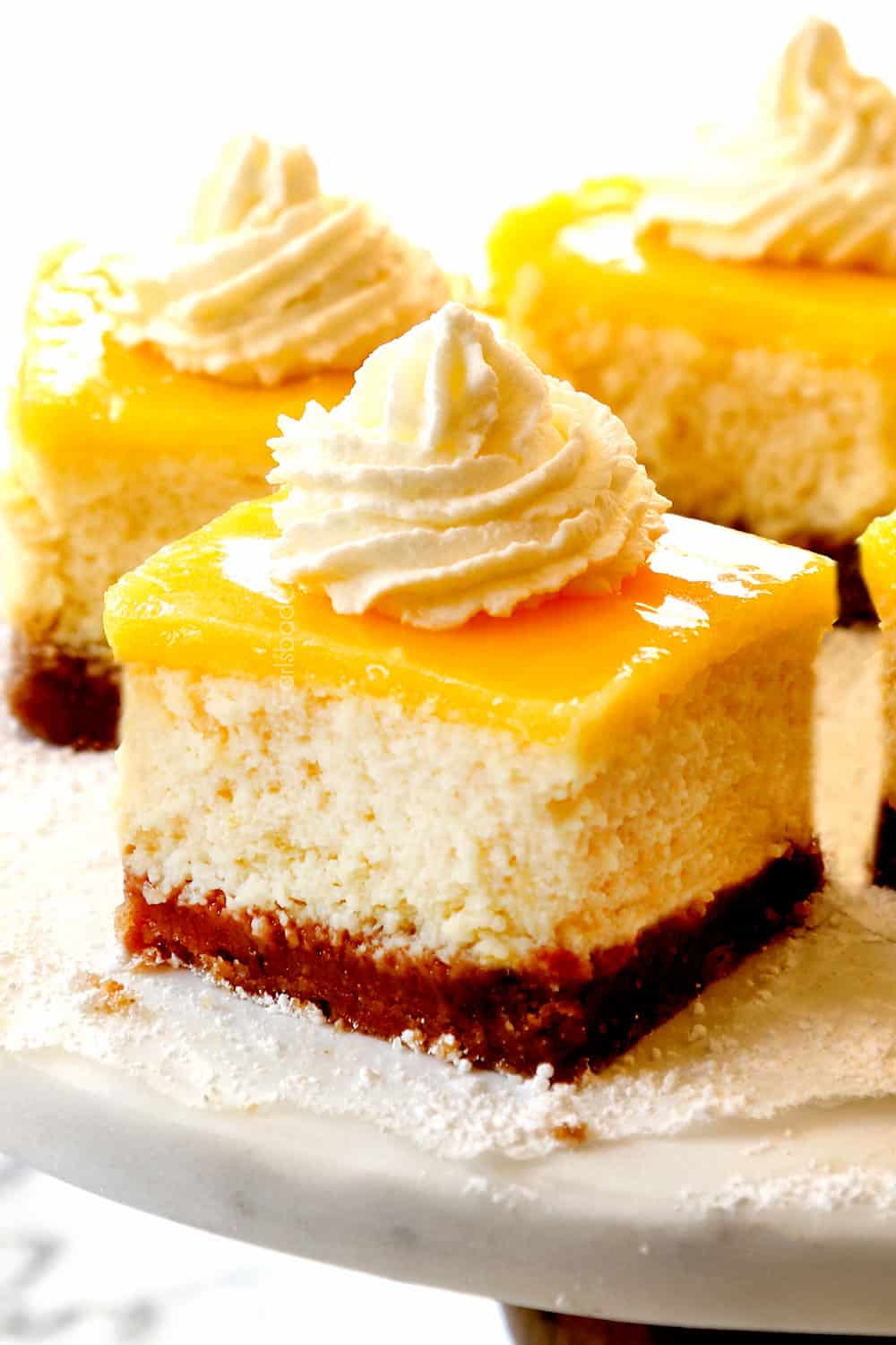 showing how to use lemon curd by adding them on top of cheesecake bars